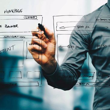 Business person using a marker to draw the relationships between various elements of a website.