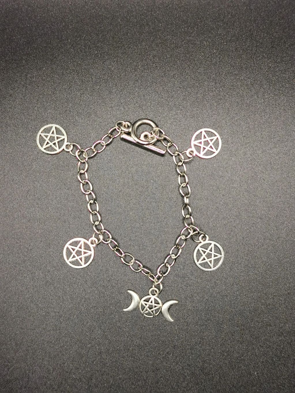 Silver charm bracelet with pentacles and moon phases.