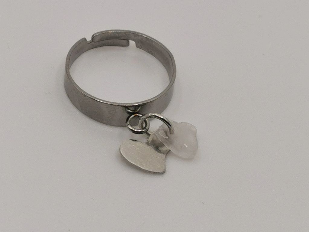 Silver ring with two small charms.