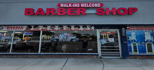 Barber shop storefront with large red signage and walk-ins welcome.