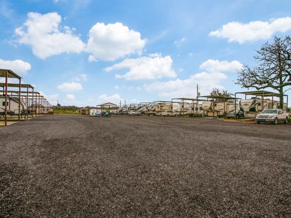 RV park with covered parking under a blue sky.