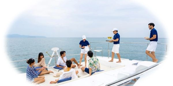 Group enjoying drinks on a yacht at sea.