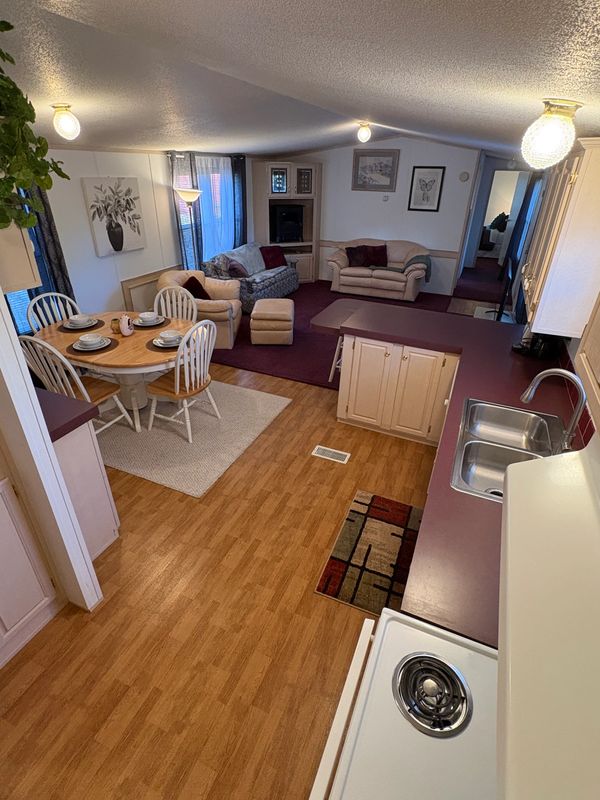 Cozy open-plan kitchen and living area with wooden floors and comfortable seating.