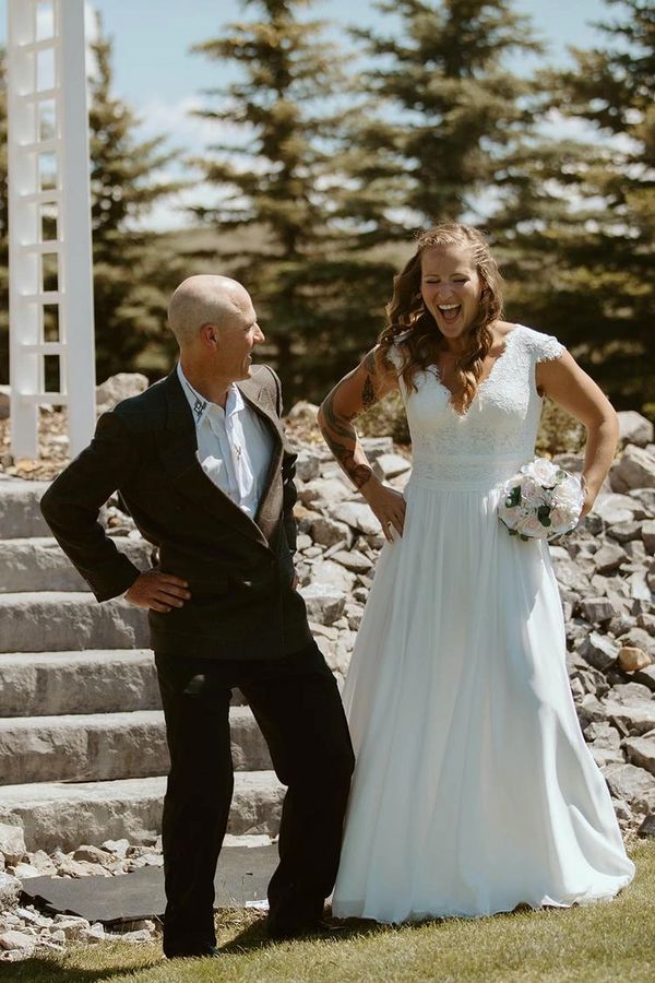 Bride and groom striking playful poses outdoors on their wedding day.