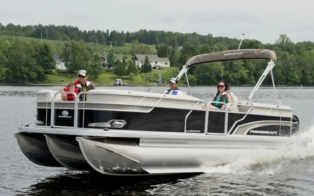 Family enjoying a ride on a pontoon boat on a lake.