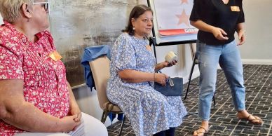 Three women engaged in a casual discussion indoors.
