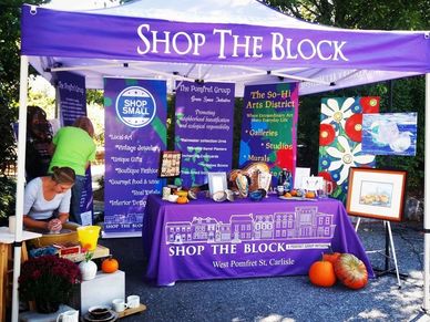 Colorful fair scene promoting local businesses with brand sign and showcasing branding packages.