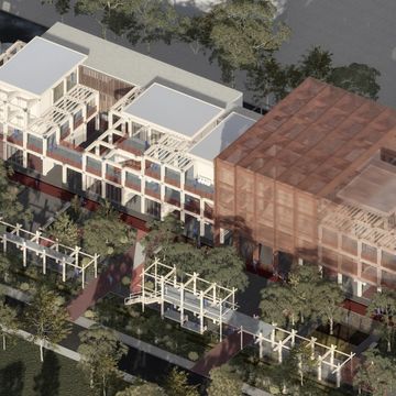 Aerial view of a modern building with a transparent orange section and surrounding trees.