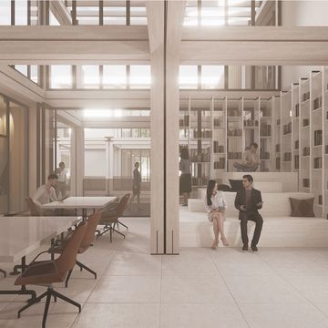 Modern co-working space with seating, bookshelves, and natural light.