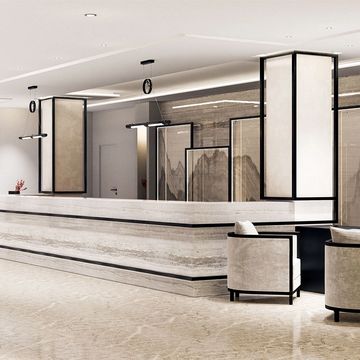 Modern hotel lobby with sleek marble reception and elegant seating.