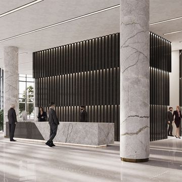 Modern office lobby with marble columns and reception desk.