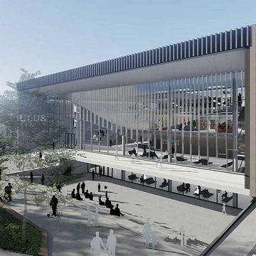 Modern architectural building with large glass windows and outdoor seating areas.