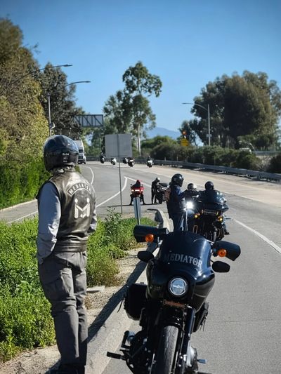 Motorcyclists from the Mediator group stopped on a sunny highway roadside.