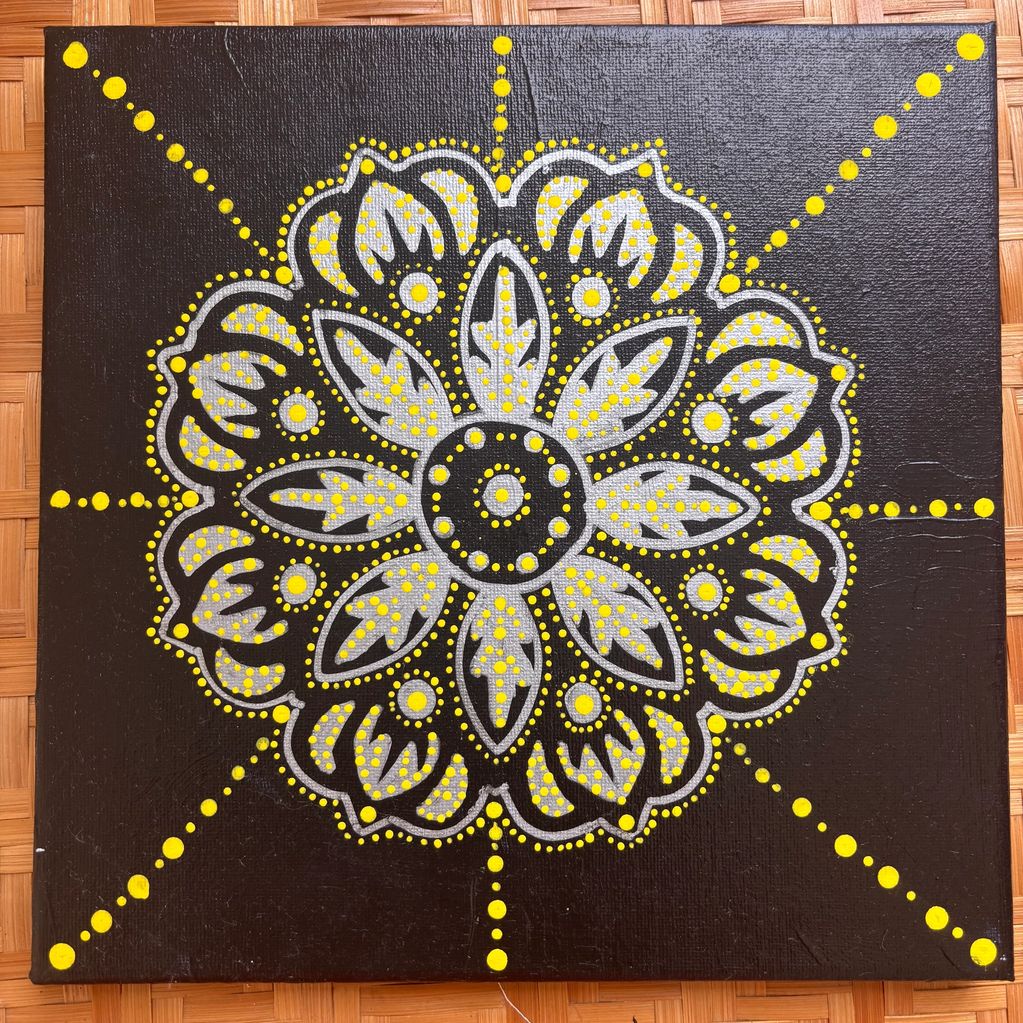 Mandala design with black, white, and yellow dots.