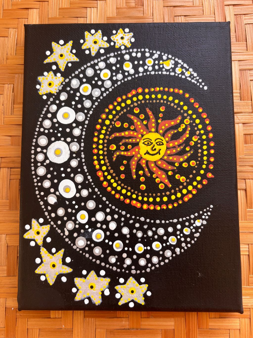Sun and moon artwork with stars on black canvas.