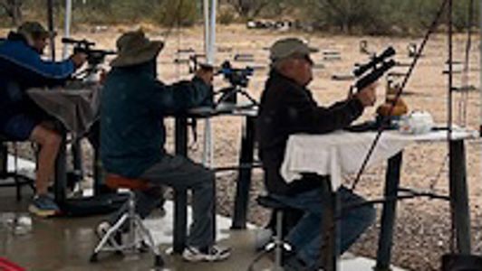 People shooting rifles at an outdoor firing range.