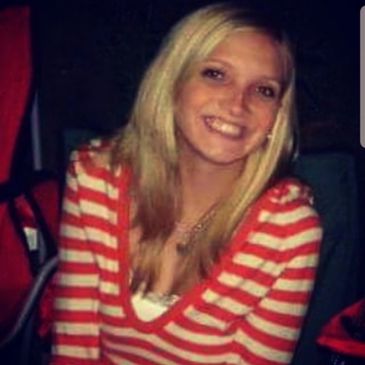Smiling woman in red and white striped top.
