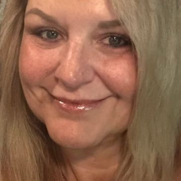 Close-up of a smiling woman with blonde hair.