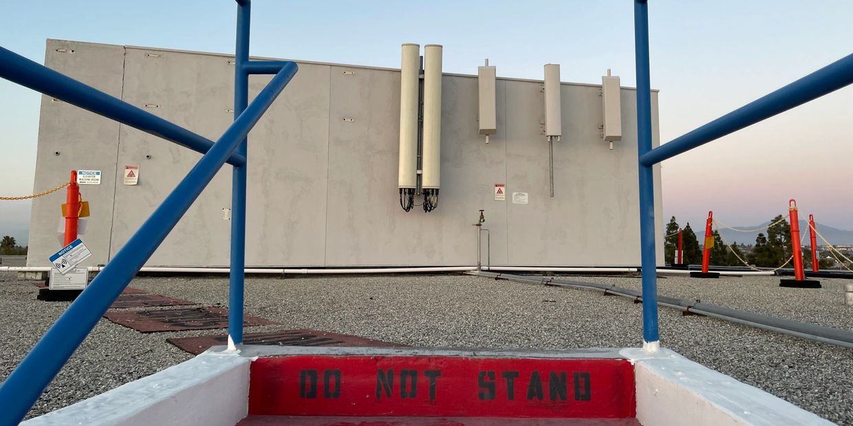 Safety signage marking restricted access areas near antennas on cellular property