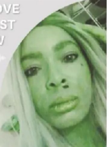 Close-up of green-tinted woman's face with long hair.