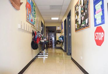 School hallway with backpacks and classroom doors.