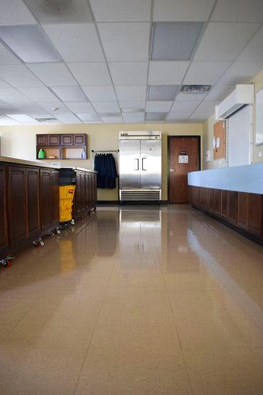 Clean polished floor in a room with wooden cabinets.