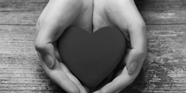 Hands holding a heart-shaped object.