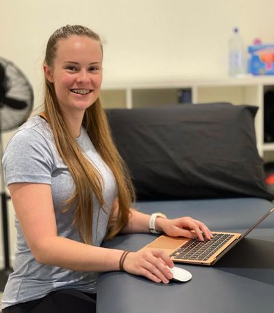 Isabelle in front of a computer on a treatment table