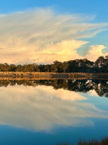 Calm lake reflecting the sky and trees at sunset.