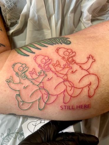 Tattoo of three outline drawings of Homer Simpson with text.