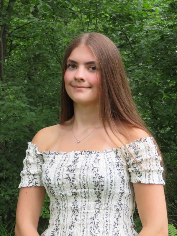 Young woman in a floral off-shoulder dress in a forest.