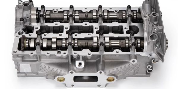 A metal engine cylinder head with camshafts.