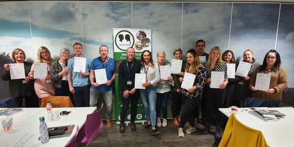 A group of people who have just completed their mental health first aid training course.