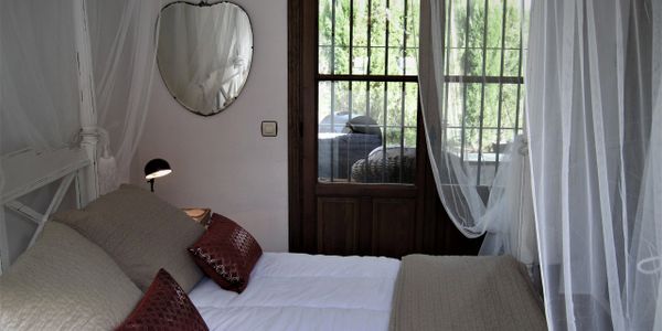 Main bedroom with romantic king size four poster bed and doors onto the terrace.