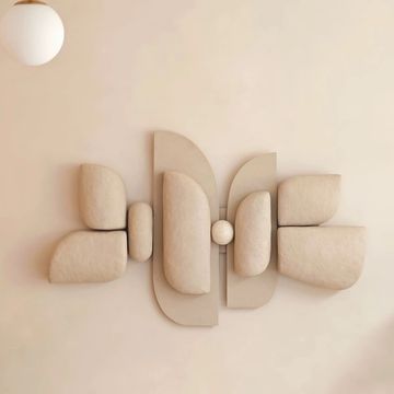Minimalist beige geometric wall sculpture with soft shapes.