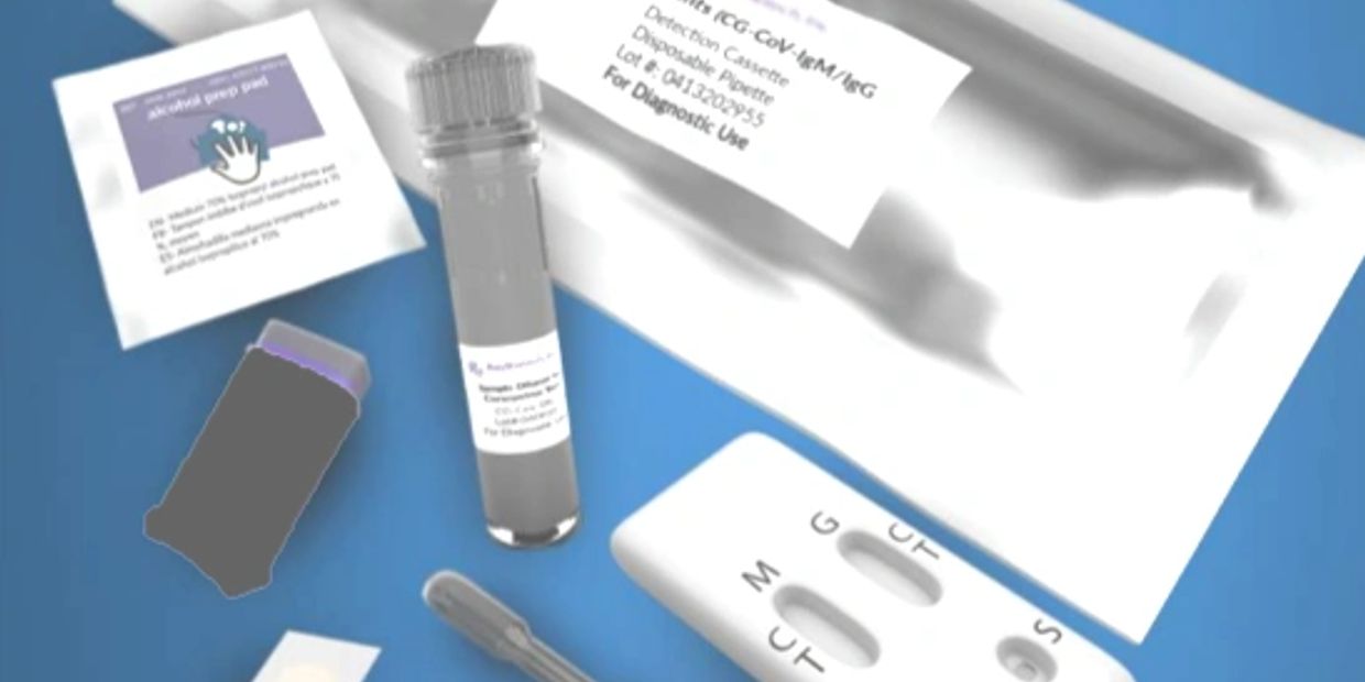 COVID-19 rapid test kit with detection cassette and accessories on a blue surface.