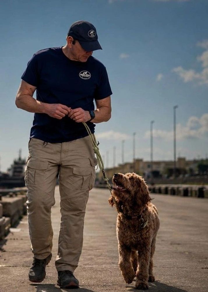 Robin walking a dog during an outdoor training session.