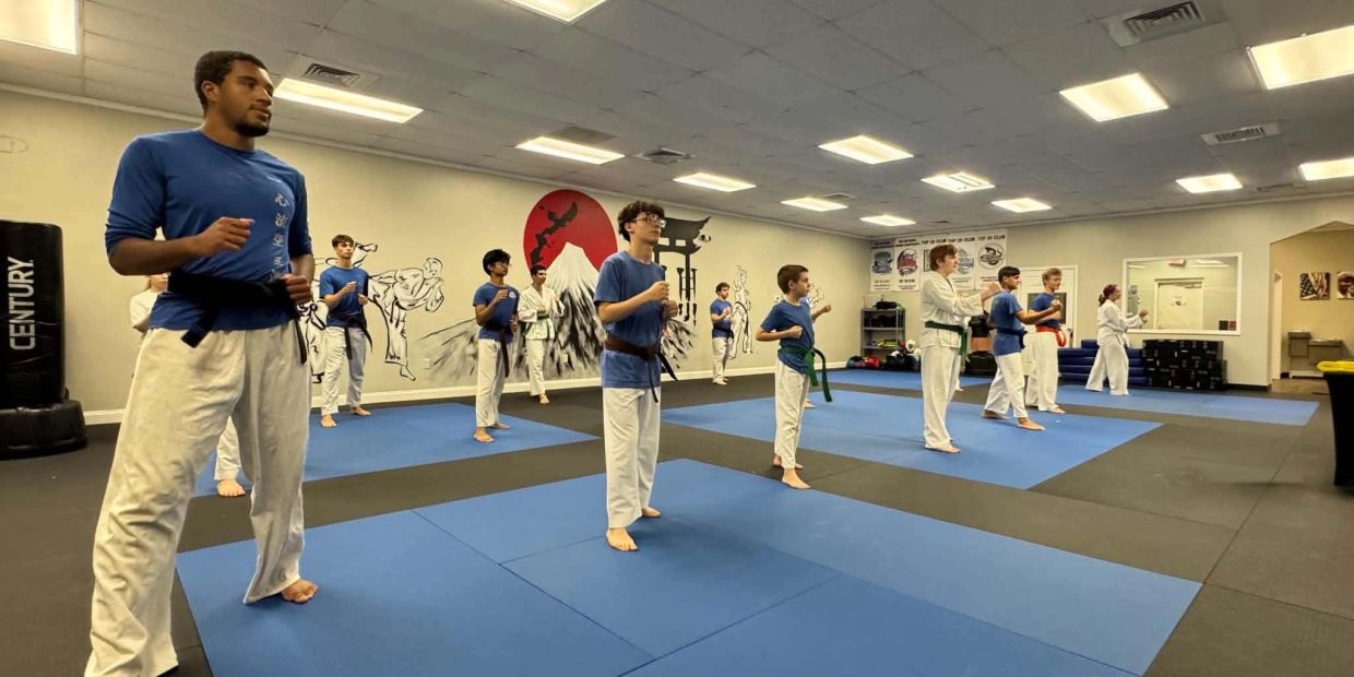 Teens and adults practicing traditional Okinawan karate during a group class at West Coast Karate in Lutz, Florida.