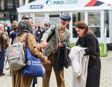 People interacting at an outdoor professional event.