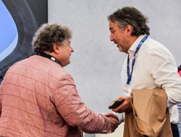Two men shaking hands and conversing.
