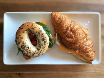 Overhead view of bagel sandwich and sausage, egg, and cheese croissant