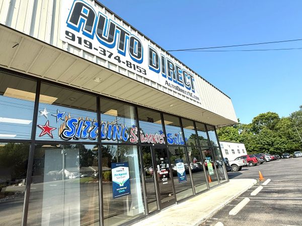 Auto Direct storefront with Sizzling Summer Sale signage and parking lot.