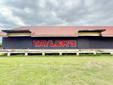 Exterior of a building with a red roof and 'TAYLOR'S' sign.