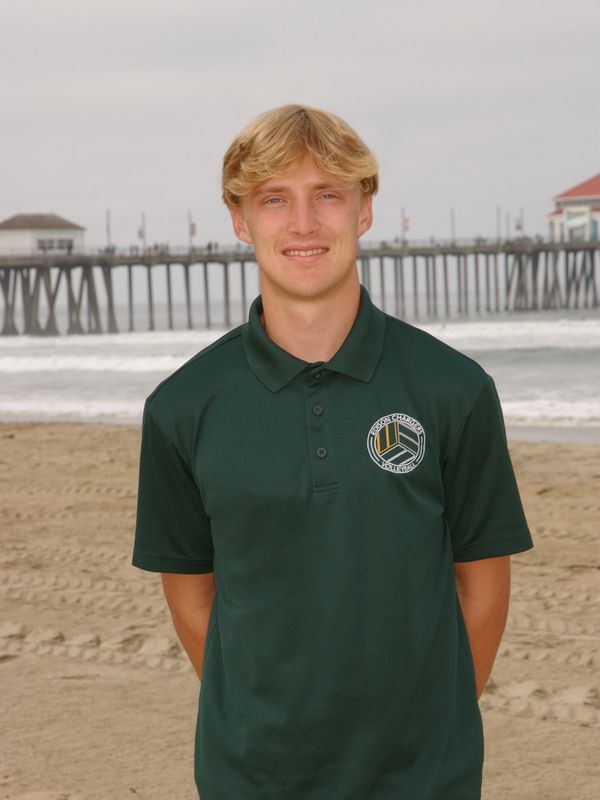 Young man in green polo shirt at the beach.