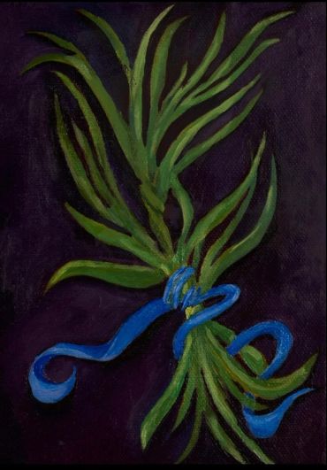 Green leaves tied with a blue ribbon on dark background.