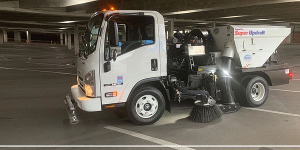 A sweeping truck in a parking lot with no trash or debris. Commercial lot sweeping wisconsin