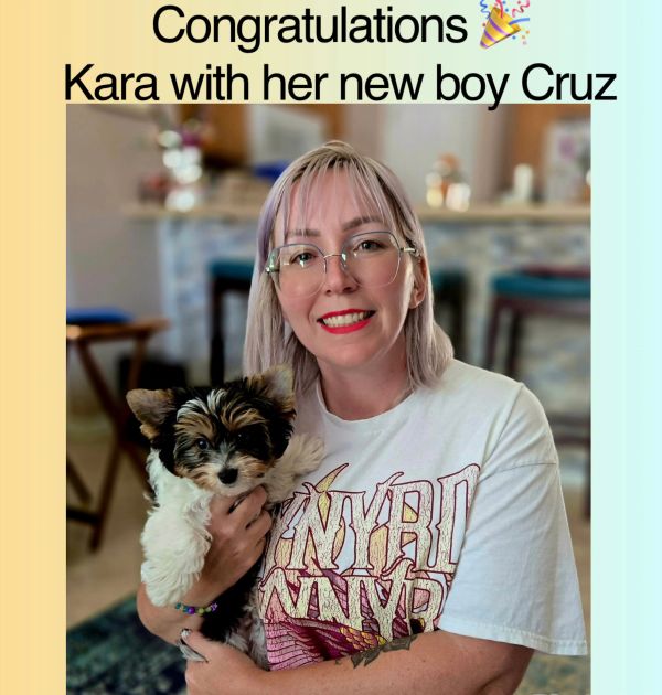 Kara happily holding her new puppy Cruz indoors.
