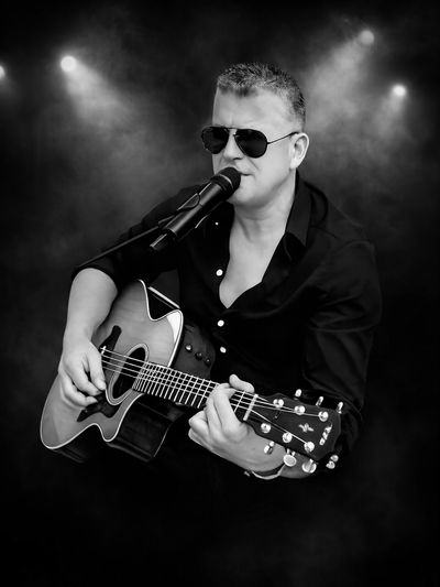 Shaun Dee playing guitar and performing