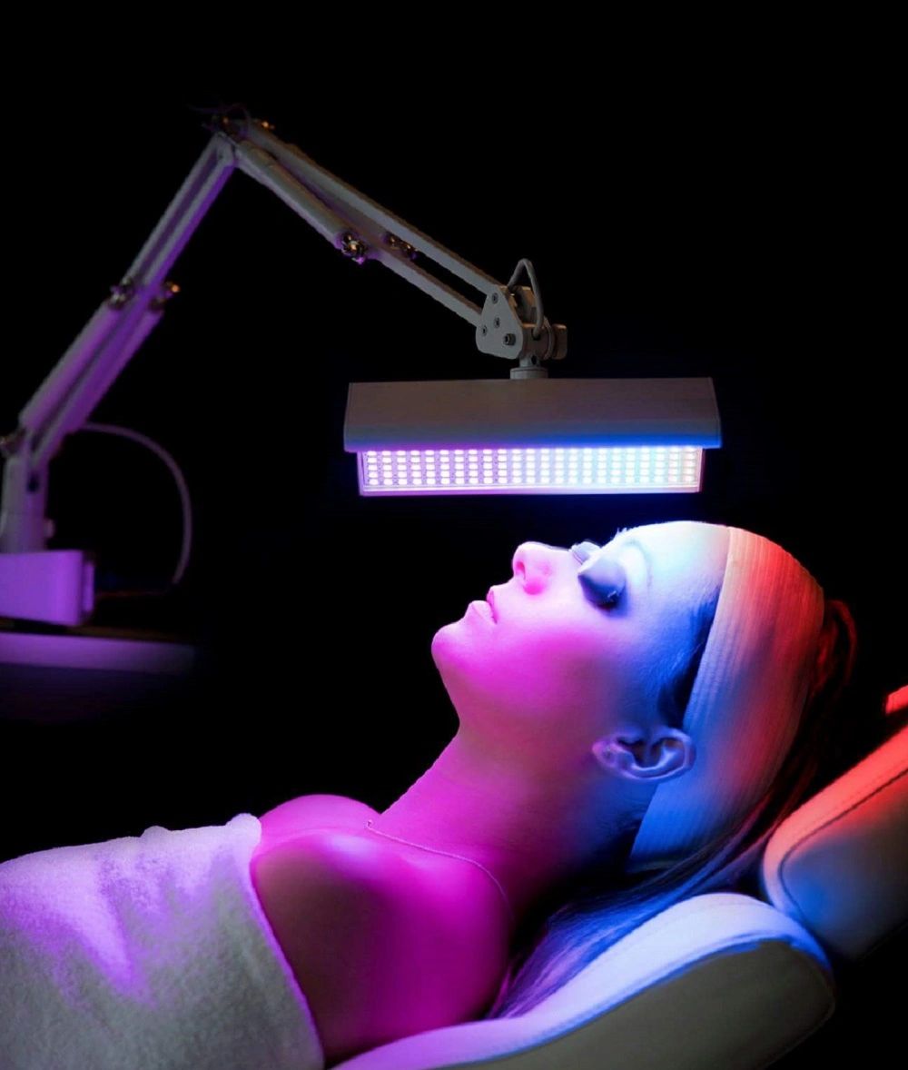 Women lying on the bed with LED light treatment