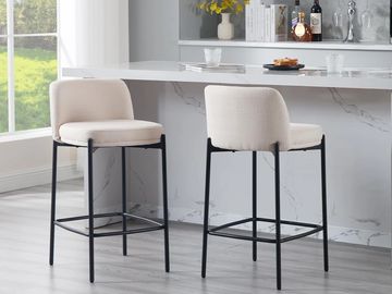 Grenada kitchen counter stools with off-white upholstery and black metal legs in front of a kitchen 